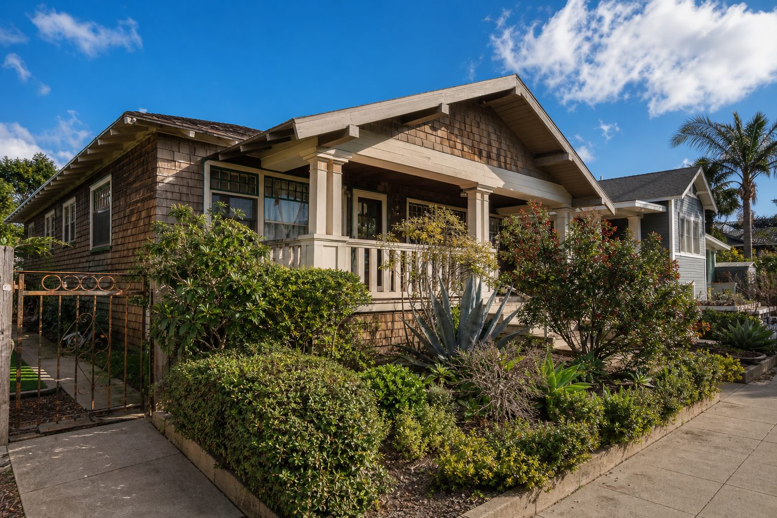 Classic California Bungalow with wood siding and entry porch surrounded by mature landscaping in North Park.