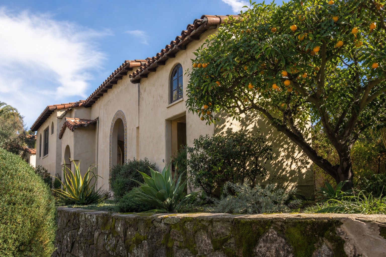 Sun-drenched Spanish Colonial Revival home with tile roof, mature orange tree, and authentic stucco patina in Mission Hills, San Diego.
