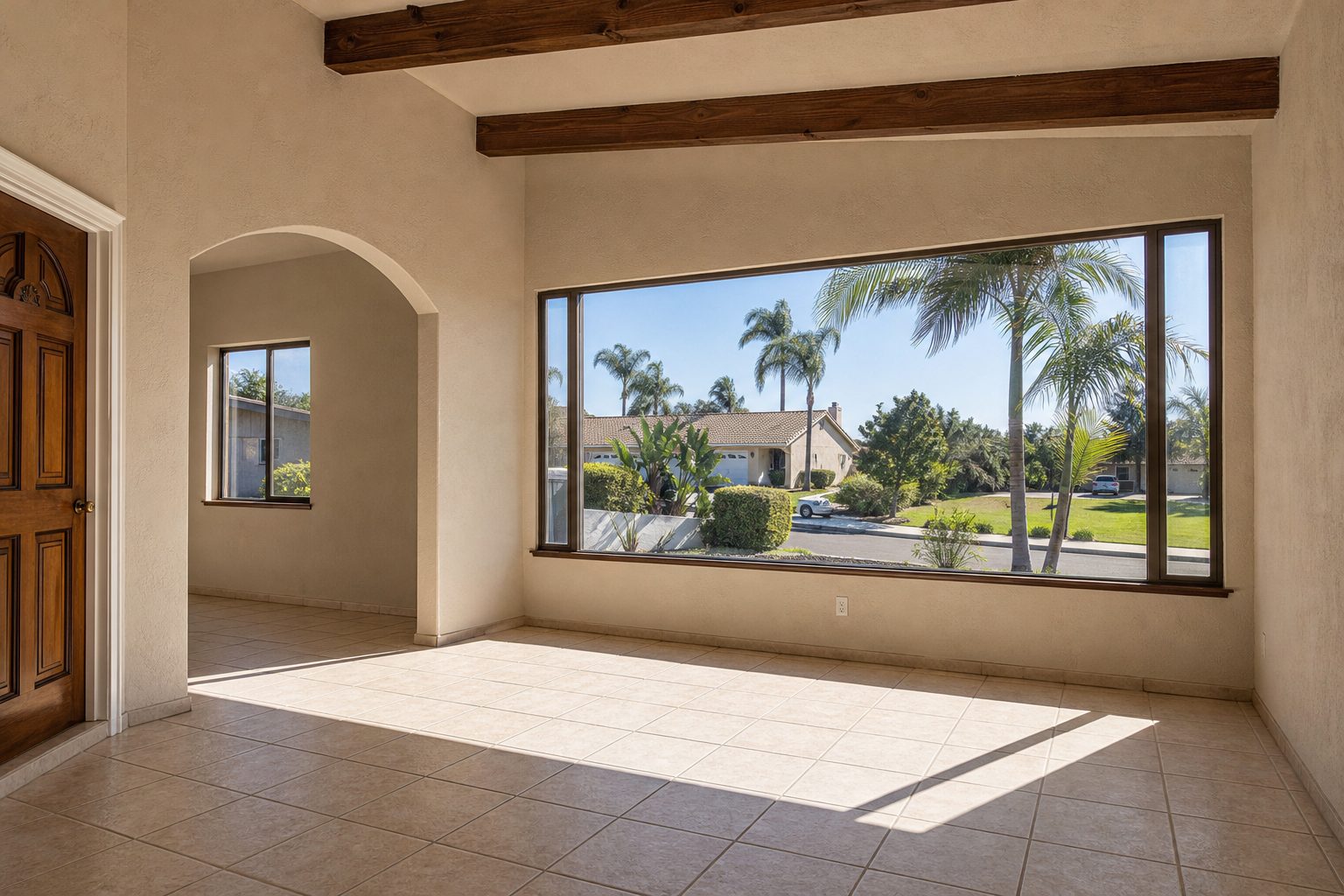 Bright interior room with large window overlooking palm-lined street in North Chula Vista residential area, natural daylight.