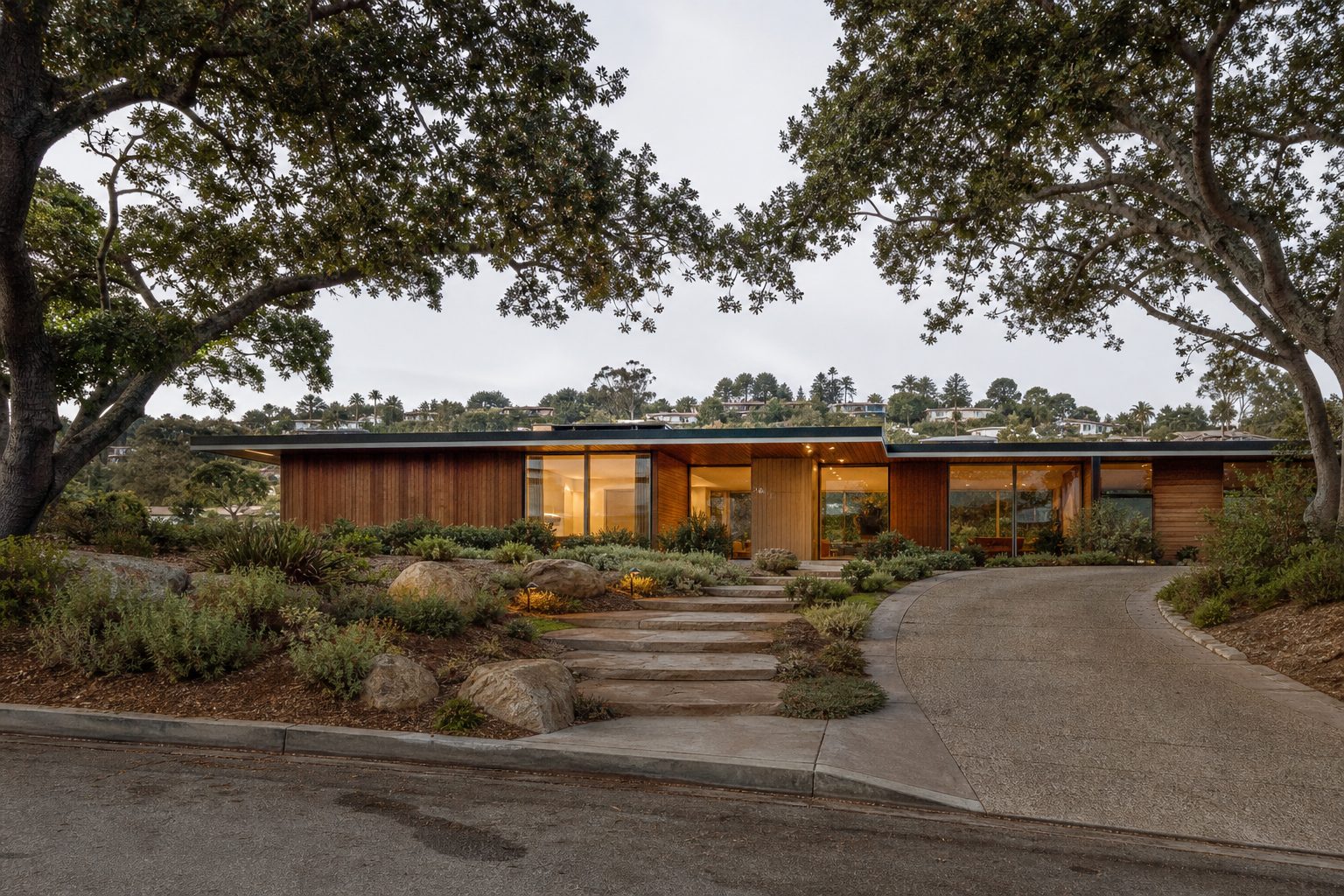 Mid-century modern luxury home with wood siding and native plantings in hillside La Jolla Heights neighborhood.