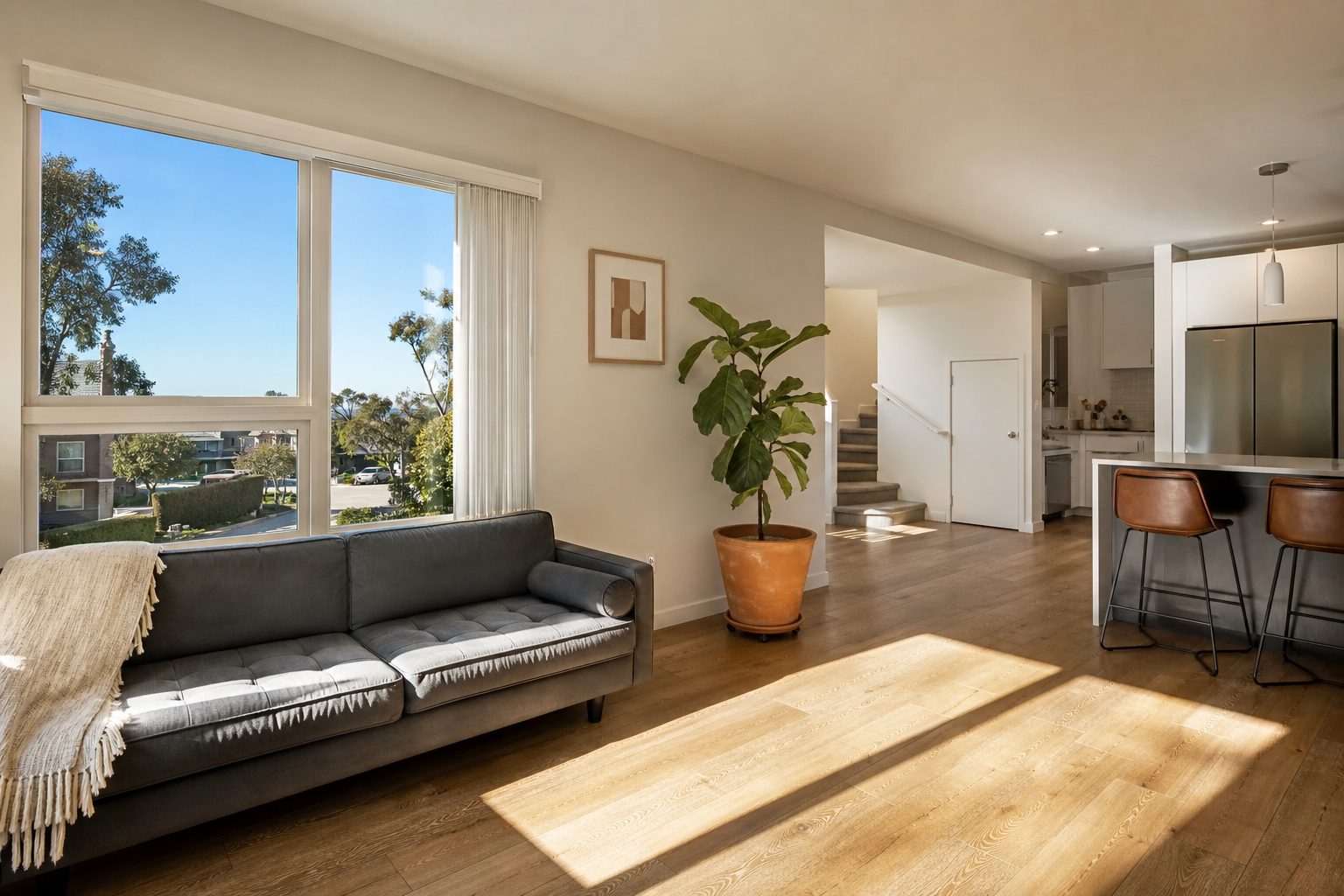 Bright open-concept townhome interior with natural light, wood flooring, and windows in Clairemont.